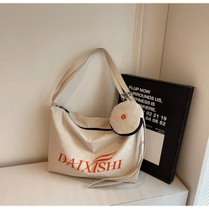 Close-up of minimalist off-white canvas tote bag with orange logo and small round pouch