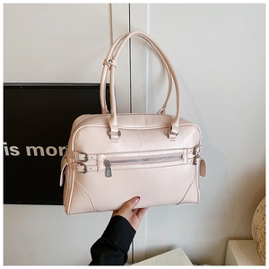 Detail of light pink bowling bag showing front zipper pocket and matte leather texture