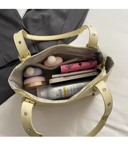 Vue de l'intérieur du sac fourre-tout crème avec compartiments et poche zippée pratique