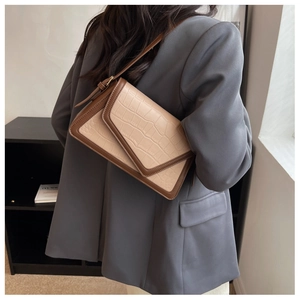 Detail of faux crocodile texture leather handbag with contrast trim in beige and brown