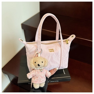 Détail du sac à main plissé rose avec fermeture éclair dorée et charm peluche chien