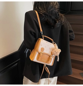 Détail d'un mini sac à dos vintage avec pendentif ours et bretelles en cuir