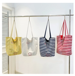 Détail de sacs cabas en toile avec motifs rayés et graphismes de chiens mignons