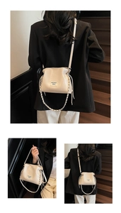 Detail of cream drawstring bucket bag with silver chain and mikaxiqi leather label