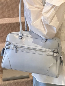 Chic silver bowling handbag for women featuring glossy leather and metallic buckles