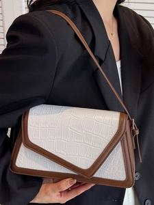 White crocodile pattern shoulder bag with brown trim worn with black blazer