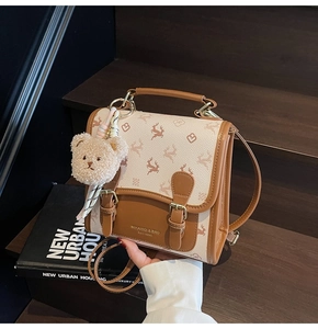 Détail du sac à dos en toile vintage avec imprimés cerf, sangles cuir et ours en peluche