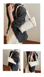 Sac sous le bras minimaliste en cuir blanc porté avec un blazer gris et une jupe plissée