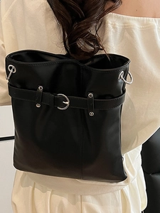 Large black pleated bucket bag with silver buckle and leather strap on model back