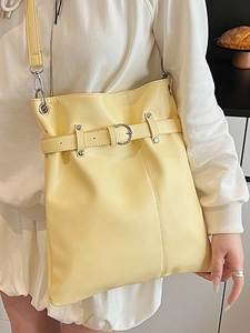 Chic cream yellow drawstring bucket bag with silver rings and soft leather texture