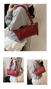 Gros plan détaillé du sac sous le bras en cuir rouge foncé avec des boucles métalliques