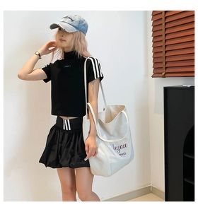 Vue détaillée de la jupe de tennis noire avec taille rayée blanche et ourlet plissé