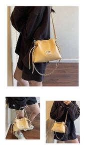 Detail of light yellow PU leather shell bag with drawstring pleats and metal chain
