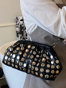 Sac à main noir orné de rivets avec bandoulière chaîne argentée porté à l'épaule