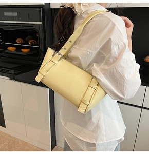 Vue lifestyle d'un sac à bandoulière en cuir structuré jaune pâle avec boucles