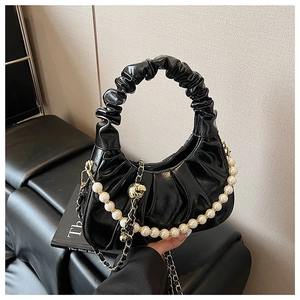 Detail of black glossy cloud bag with pleated texture and pearl chain strap