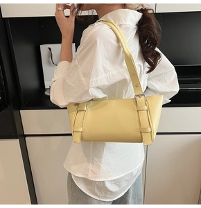 Détail d'un sac sous le bras jaune vif en similicuir avec boucles métalliques décoratives