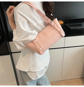 Détail du sac sous le bras en cuir rose avec boucle argentée et large bandoulière réglable