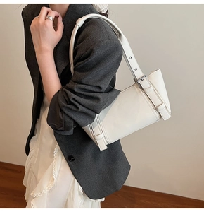 Détail du sac sous le bras blanc crème avec bandoulière à boucle argentée réglable