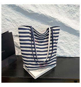 Détail du sac fourre-tout en toile à rayures bleues et blanches avec broderie rouge