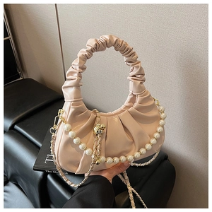 Detail of light pink cloud bag with ruched handle and elegant pearl chain accessory