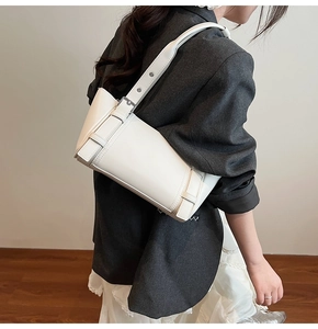 Détail du sac sous l'aisselle en cuir blanc avec boucle décorative et bandoulière
