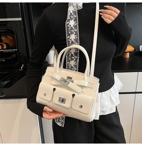 Detail of white tote bag featuring double utility pockets and silver turn-lock hardware