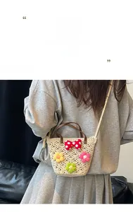 Close-up of handmade woven straw bag with colorful crochet flowers and a polka dot bow