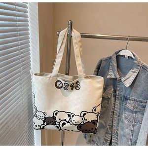 Detailed close-up of a canvas tote bag featuring cute cartoon bear prints and digital pattern