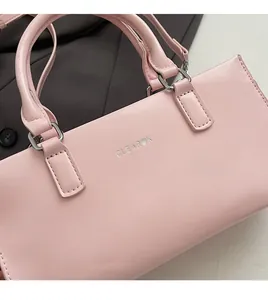 Close-up of pink matte leather handbag detail showing soft texture and silver metallic buckle