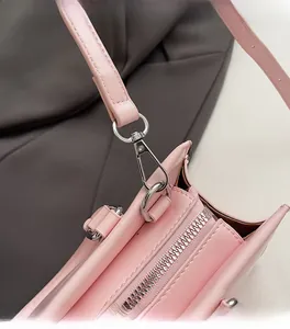 Detailed view of pink leather handbag with premium silver metal hook and zipper closure