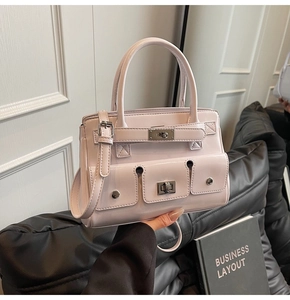 Close-up of pink shoulder bag featuring multiple pockets and elegant metal turn-lock closure