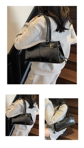 Close-up of black patent leather shoulder bag with vintage buckle details and glossy finish