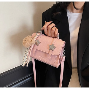 Pink crossbody bag with star metal buckles and a cute plush bear charm detail
