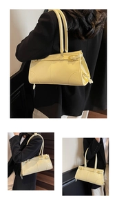 Detail view of cream yellow pleated shoulder bag with gold metal buckle and dual straps