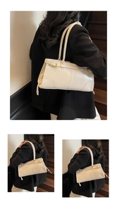 Detail view of white pleated shoulder bag featuring vintage gold buckle and fine stitching