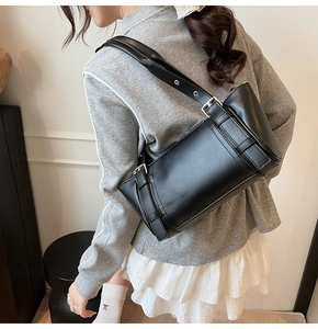 Vue latérale d'un sac cylindrique en cuir noir avec bandoulière réglable à œillets