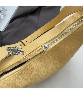 Gros plan d'un sac en cuir jaune grainé avec fermeture éclair en métal argenté poli