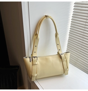 Vue détaillée d'un sac d'épaule jaune pâle en similicuir avec bandoulière réglable et boucles