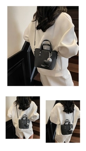 Detail of black lychee grain leather bucket bag with silver studs and heart charm