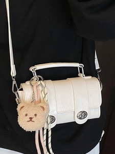 White faux crocodile skin messenger bag with silver clasp and plush bear charm decoration