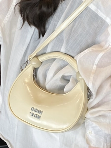 Chic cream-white patent leather crescent handbag with silver metal lettering and strap