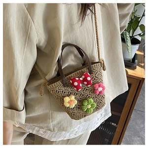 Detail of woven floral crossbody bag with 3D crochet flowers and red polka dot bow