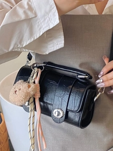 Chic black crocodile pattern cylinder bag with silver twist lock and bear charm