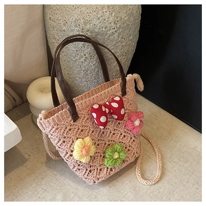 Detailed knit texture of pink woven bag with floral accents and red polka dot bow decoration