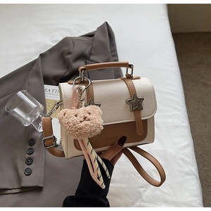 Detailed shot of leather crossbody bag with star accents and plush bear keychain