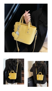 Detail of yellow lychee leather bucket bag with top handles and adjustable shoulder strap