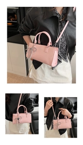 Close-up of pink glossy leather shoulder bag with a metallic silver bow charm detail
