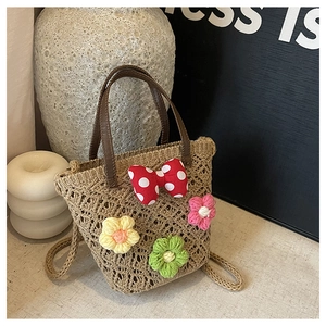 Detail of woven floral beach bag with polka dot bow and colorful knit flowers