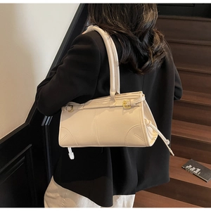 Chic cream white underarm bag with gold buckle detail shown on a female model
